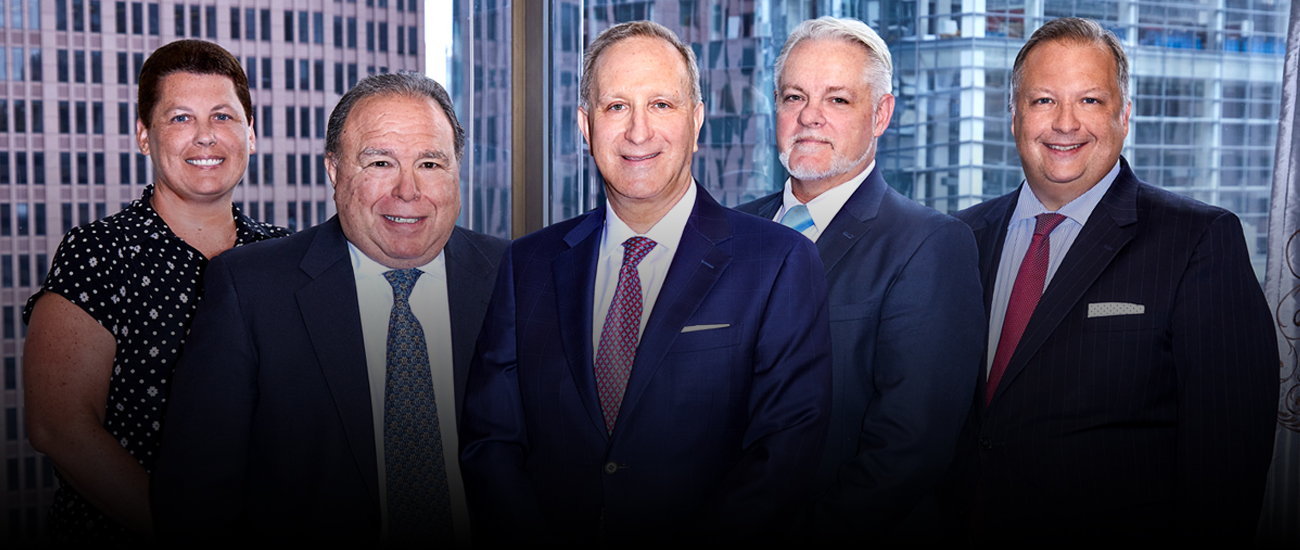 Group photo of the Law Offices of Leon Aussprung MD, LLC with buildings in the background.